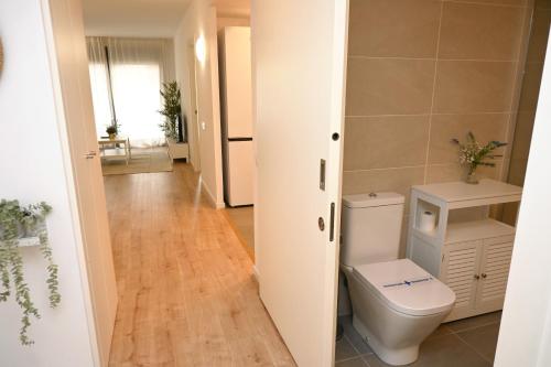 a bathroom with a toilet and a hallway at Homenfun Barcelona Can Serra in Hospitalet de Llobregat