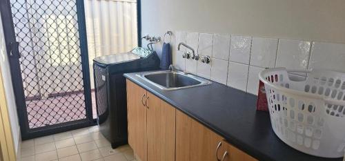 a kitchen with a sink and a trash can at Peaceful Escape in Perth