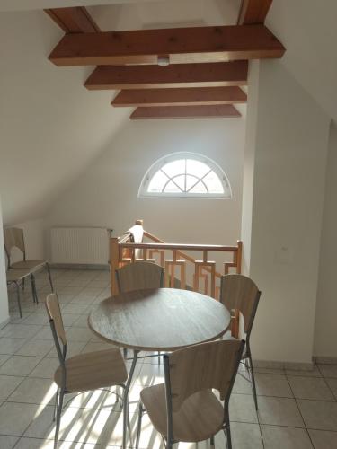 einen Tisch und Stühle in einem Zimmer mit Fenster in der Unterkunft Katerina Vendégház in Tihany