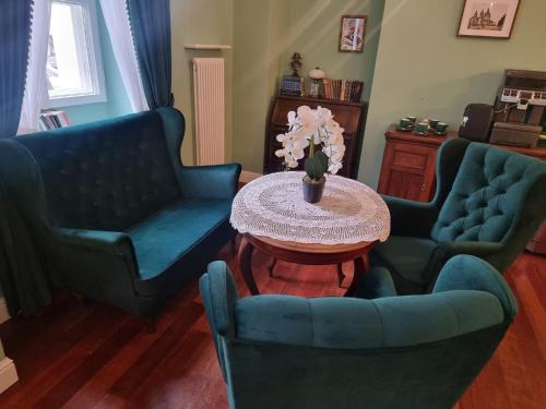 a living room with two blue chairs and a table at Tiffi Old Town Hotel in Warsaw