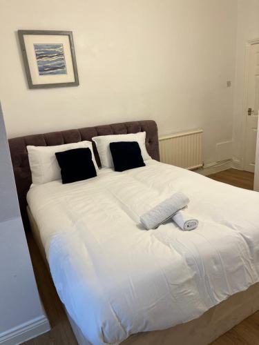 De Luxe apartment 1 في ليستر: سرير أبيض كبير مع ريموت كنترول عليه