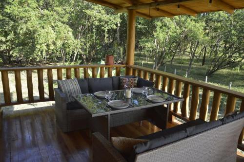 una mesa y sillas en una terraza de madera en Maison autonome en bois, à Brasilito, en Brasilito