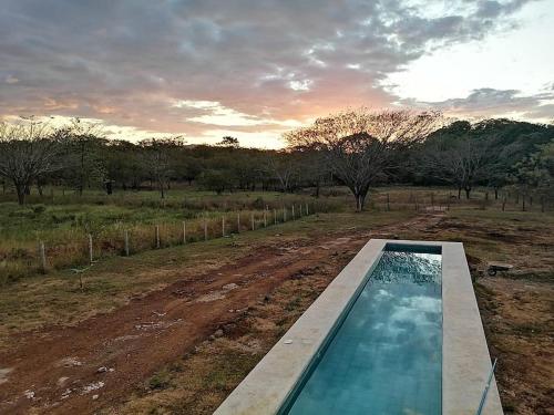 una piscina in mezzo a un campo di terra di Maison autonome en bois, à Brasilito a Brasilito