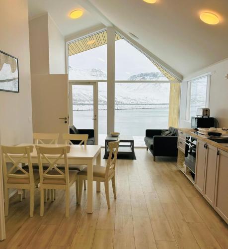 una cucina e un soggiorno con tavolo e sedie di Fisk Club Cottages a Suðureyri