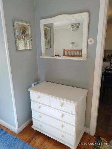 a bedroom with a white dresser and a mirror at Molidens Gästgiveri Jönköping in Jönköping