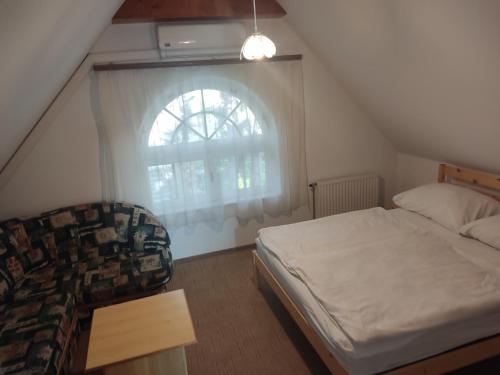 Schlafzimmer mit einem Bett und einem Fenster in der Unterkunft Katerina Vendégház in Tihany