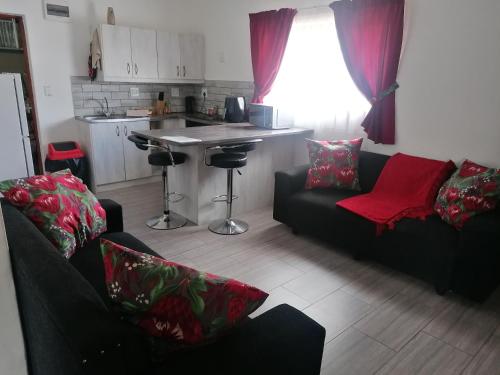 sala de estar con 2 sofás y cocina en Kosies Nest Gastehuis, en Ciudad del Cabo