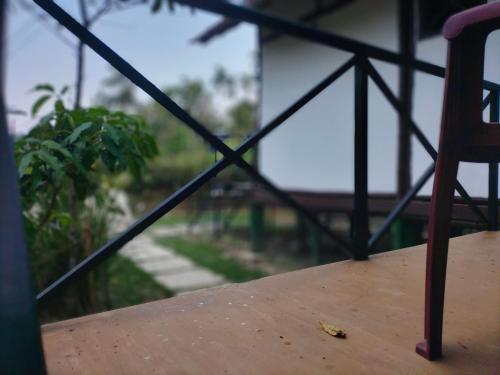 卡爾佩特塔的住宿－Oryza wayanad，阳台上配有一张木桌和椅子
