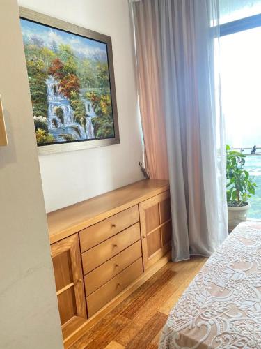 a bedroom with a dresser and a painting on the wall at Avenue K in Kuala Lumpur