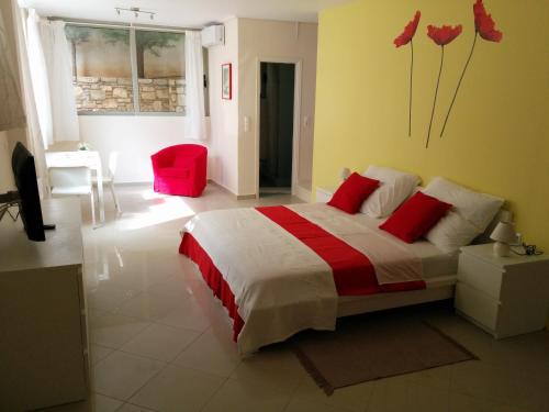 ein Schlafzimmer mit einem großen Bett mit roten Kissen in der Unterkunft Petalidi Beachview in Petalidi