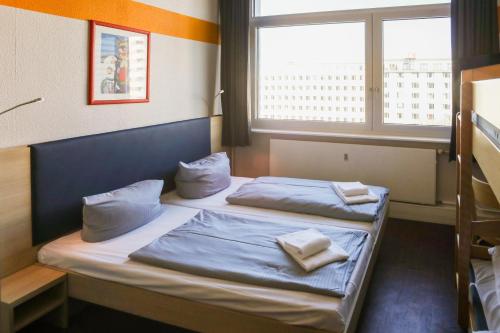 a bedroom with two beds with pillows and a window at acama Hotel & Hostel Kreuzberg in Berlin