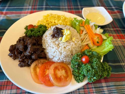 a plate of food with rice and vegetables on a table at Clark CU Hotel in Angeles