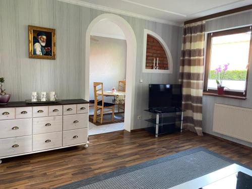 a living room with a white dresser and a television at Gemütliche Ferienwohnung in Gingst