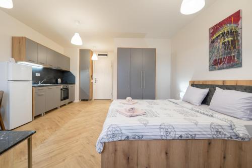 a bedroom with a large bed and a kitchen at WOW studios for rent 2 bul Montevideo 25A - B in Sofia