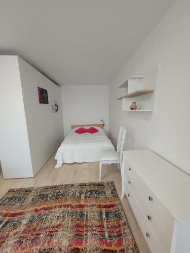 a white bedroom with a bed and a rug at Апартаменты in Rīga