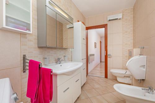 baño con lavabo y 2 aseos en Apartment Ive, en Mlini