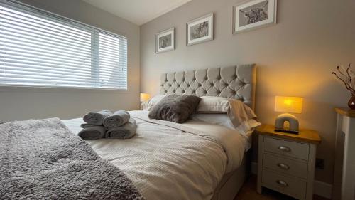 a bedroom with a bed with towels on it at Braeview, Contemporary Luxury NC500 Holiday Home - Sleeps 5 in Wick