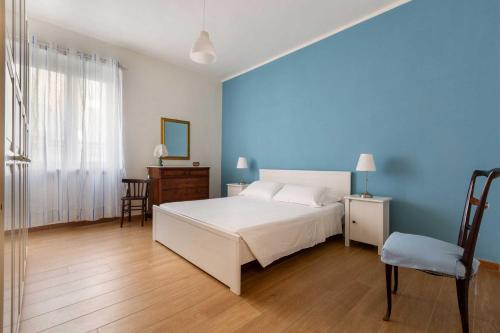 a bedroom with a white bed and a blue wall at Balconcino sul Rivellino by BarbarHouse in Gallipoli