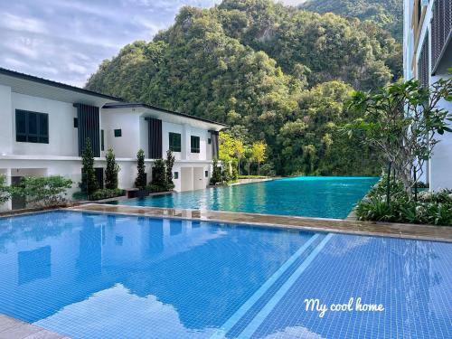 a swimming pool in front of a building with a mountain at Sunway Onsen Suite Theme Park View Top Floor at Lost World in Tambun