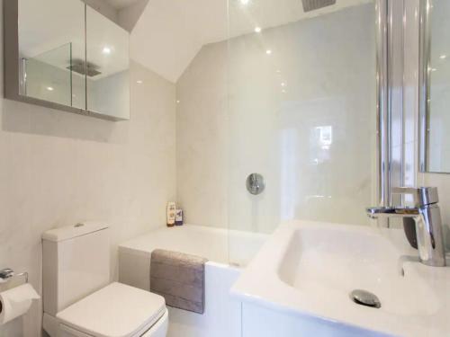 ein weißes Bad mit einem WC und einem Waschbecken in der Unterkunft Paddington Apartment 5mins from St Mary Hospital Pass the Keys in London