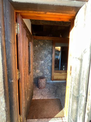 an open door to a room with a stone wall at Casa dos Toros in Cortes do Meio