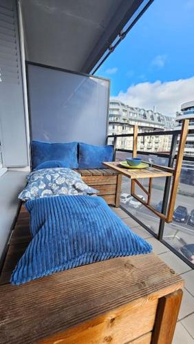 - un balcon avec un lit et une table sur un bateau dans l'établissement Le Salin - Terrasse - Parking - Wifi, à Clermont-Ferrand