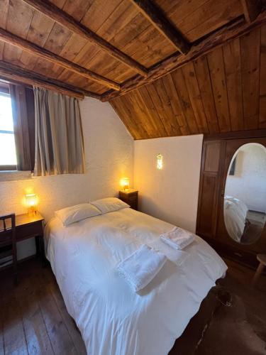 a bedroom with a large white bed with a mirror at Casa dos Toros in Cortes do Meio