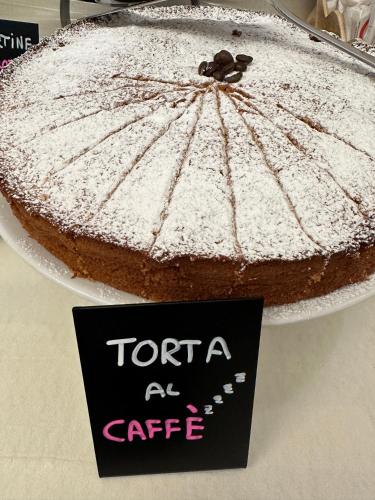 a cake on a plate with a sign in front of it at Hotel La Plage in Cattolica