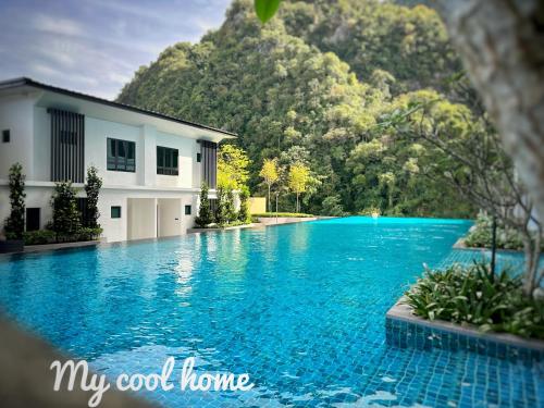 a swimming pool in front of a house and a mountain at Sunway Onsen Suite Theme Park View Top Floor at Lost World in Tambun