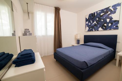 Un dormitorio con una cama azul y una ventana en Villa Gabriella, en Leuca