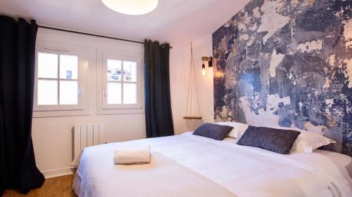 a bedroom with a large white bed with a black wall at Home Chic Home - Les Toits de Sainte-Ursule in Montpellier