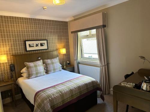 a hotel room with a bed and a window at Cairngorm Hotel in Aviemore