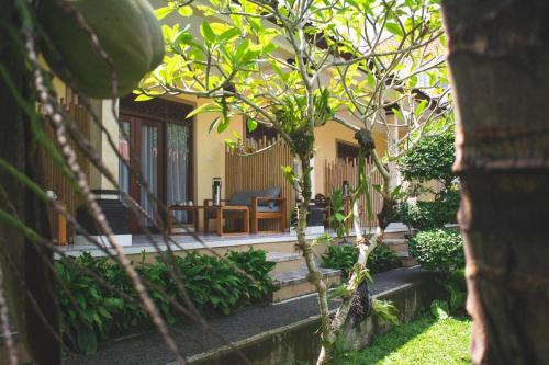 un porche de una casa con una mesa y una silla en Sastra Ubud House, en Ubud