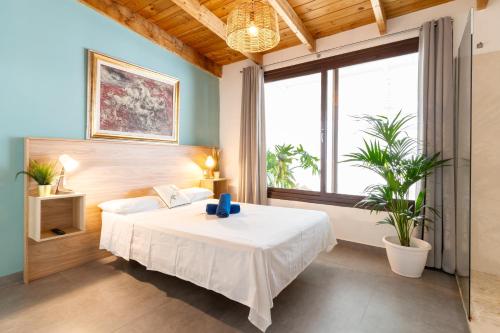 a bedroom with a white bed and a large window at Villa Neon Tenerife in Arona