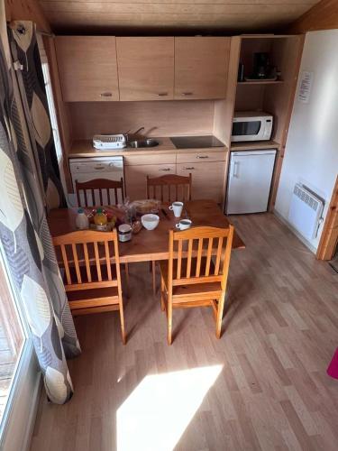 une petite cuisine avec une table et des chaises en bois dans l'établissement Domaine Lou Cevenol, à Aulas