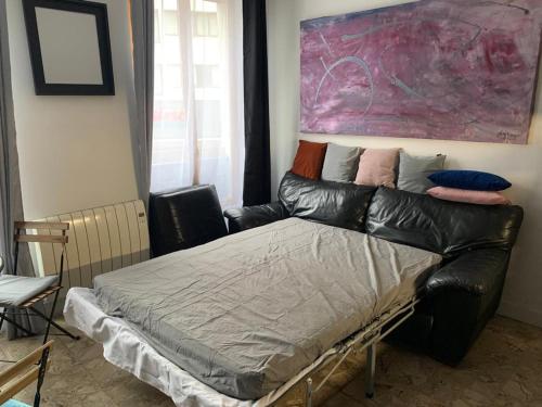 une chambre avec un lit et un tableau au mur dans l'établissement Your flat in Paris-Clichy - Available for the Olympics!, à Clichy