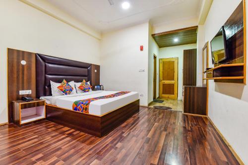 a bedroom with a large bed and a television at FabHotel Manali Heaven in Manāli