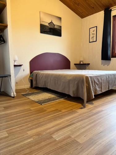 une chambre avec un grand lit et un parquet dans l'établissement BORD DE MER, à Aytré