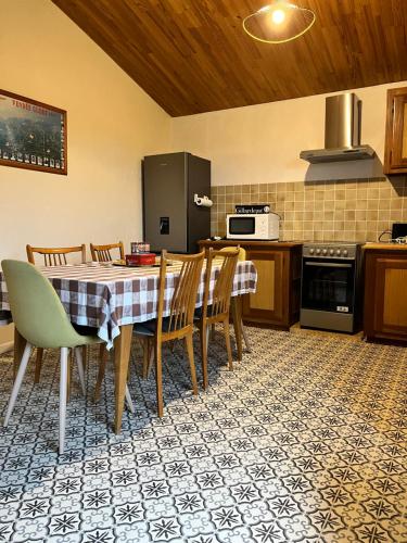 BORD DE MER في ايتريه: مطبخ مع طاولة مع كراسي وثلاجة