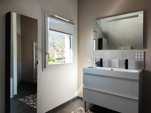 uma casa de banho com um lavatório e um espelho em Villa récente - centre St Jorioz, quartier calme, jardin terrasse, vue montagnes, à 2km du lac em Saint-Jorioz
