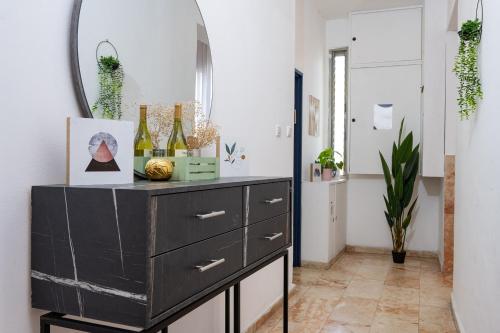 a black dresser in a room with a mirror at GODSON TALPIOT in Haifa