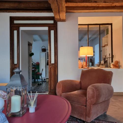 un salon avec une chaise et une table dans l'établissement La Damoiselle en Bourgogne, à Ouanne