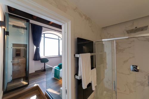 a bathroom with a shower and a glass door at Kemì Luxury Suites in Vietri sul Mare
