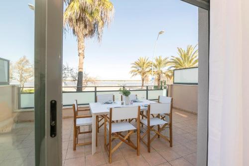 a table and chairs on a balcony with palm trees at Atardecer en Sanlúcar in Sanlúcar de Barrameda