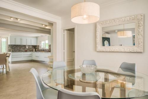 a dining room with a glass table and chairs at Villa Mila in Sant Lluis