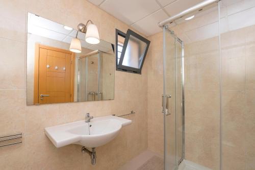 サンルーカル・デ・バラメダにあるAtardecer en Sanlúcarのバスルーム(洗面台、ガラス張りのシャワー付)