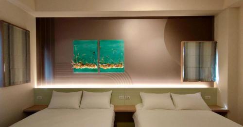 a room with two beds and a painting on the wall at Mi Hai B&B in Magong