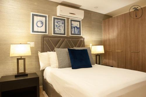 a bedroom with a large bed and two lamps at Stylish Apt. w/ Rooftop, Infinity Pool & Sea View in Mazatlán