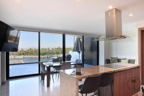 a kitchen and dining room with a view of a house at Vista a la Laguna y Amenidades Unicas in Mazatlán