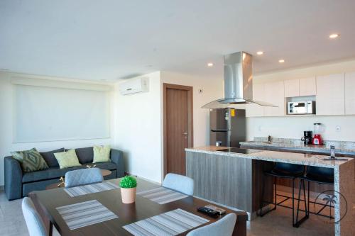 a kitchen and living room with a table and a couch at Vista a la Laguna y Amenidades Unicas in Mazatlán